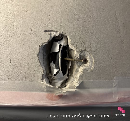 חור בקיר עם צינור ומסמר